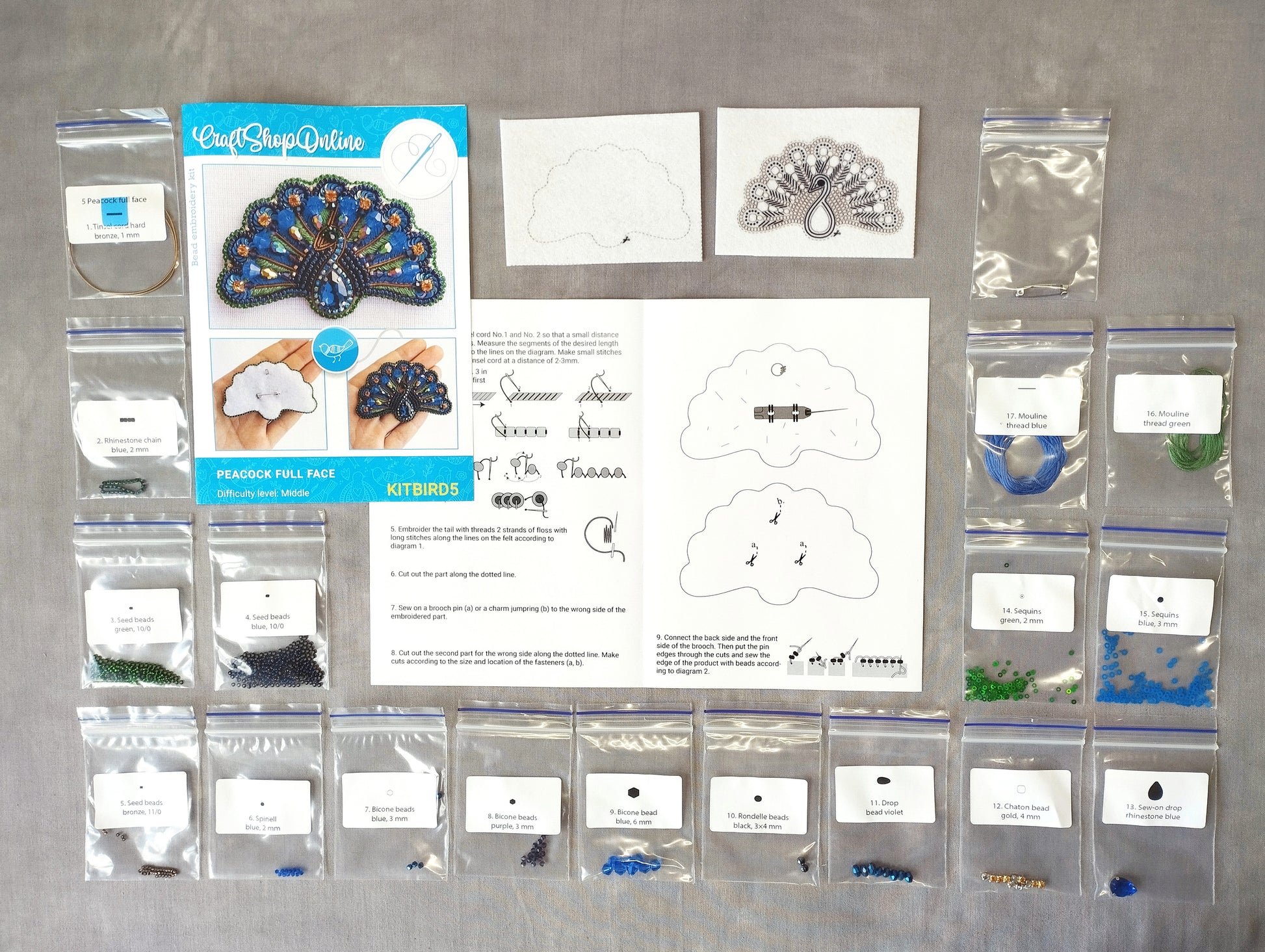 various craft supplies, including a peacock feather kit, beads, and instructions for creating a peacock-themed project.