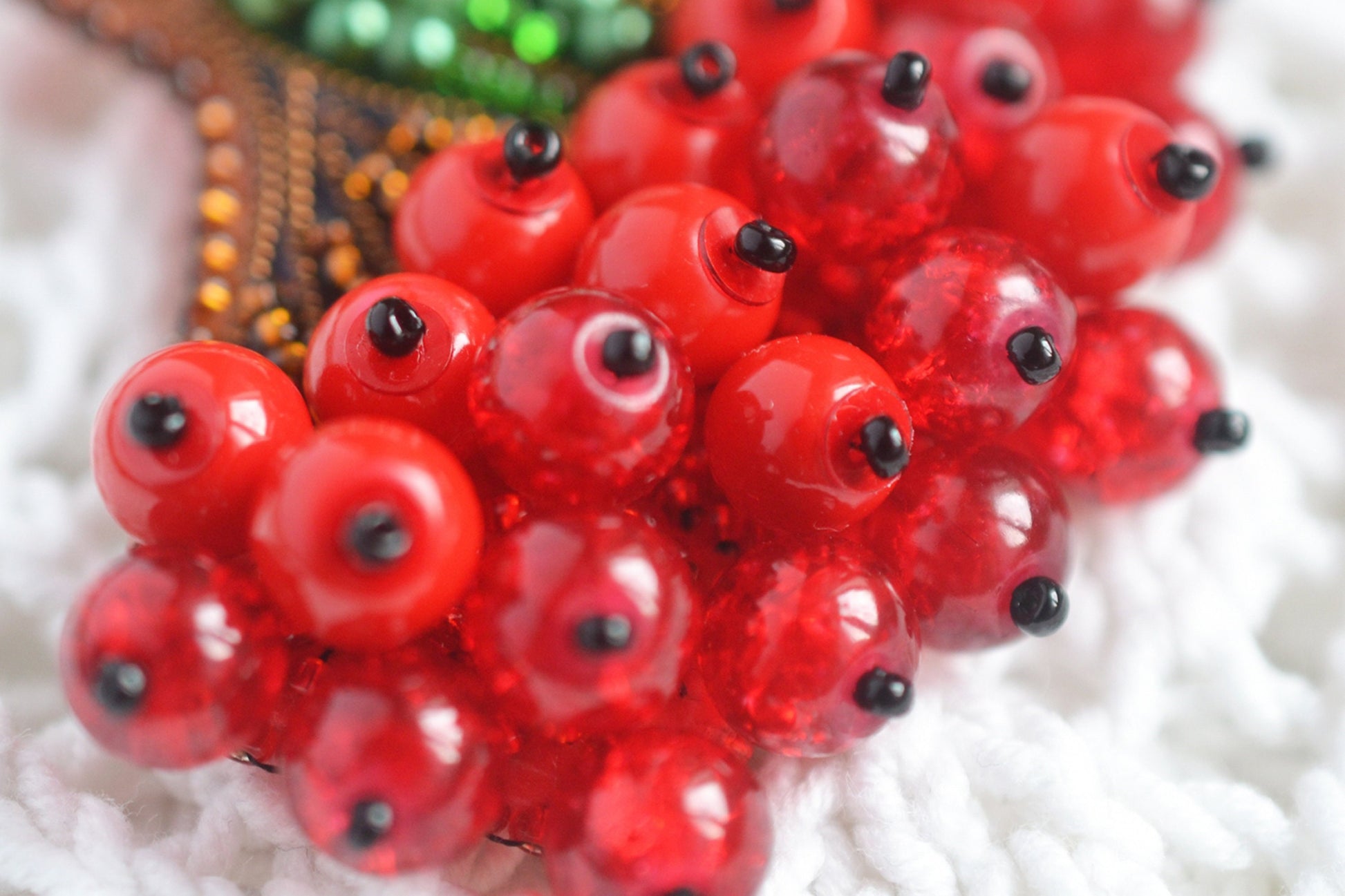 a bunch of red beads sitting on top of a white blanket