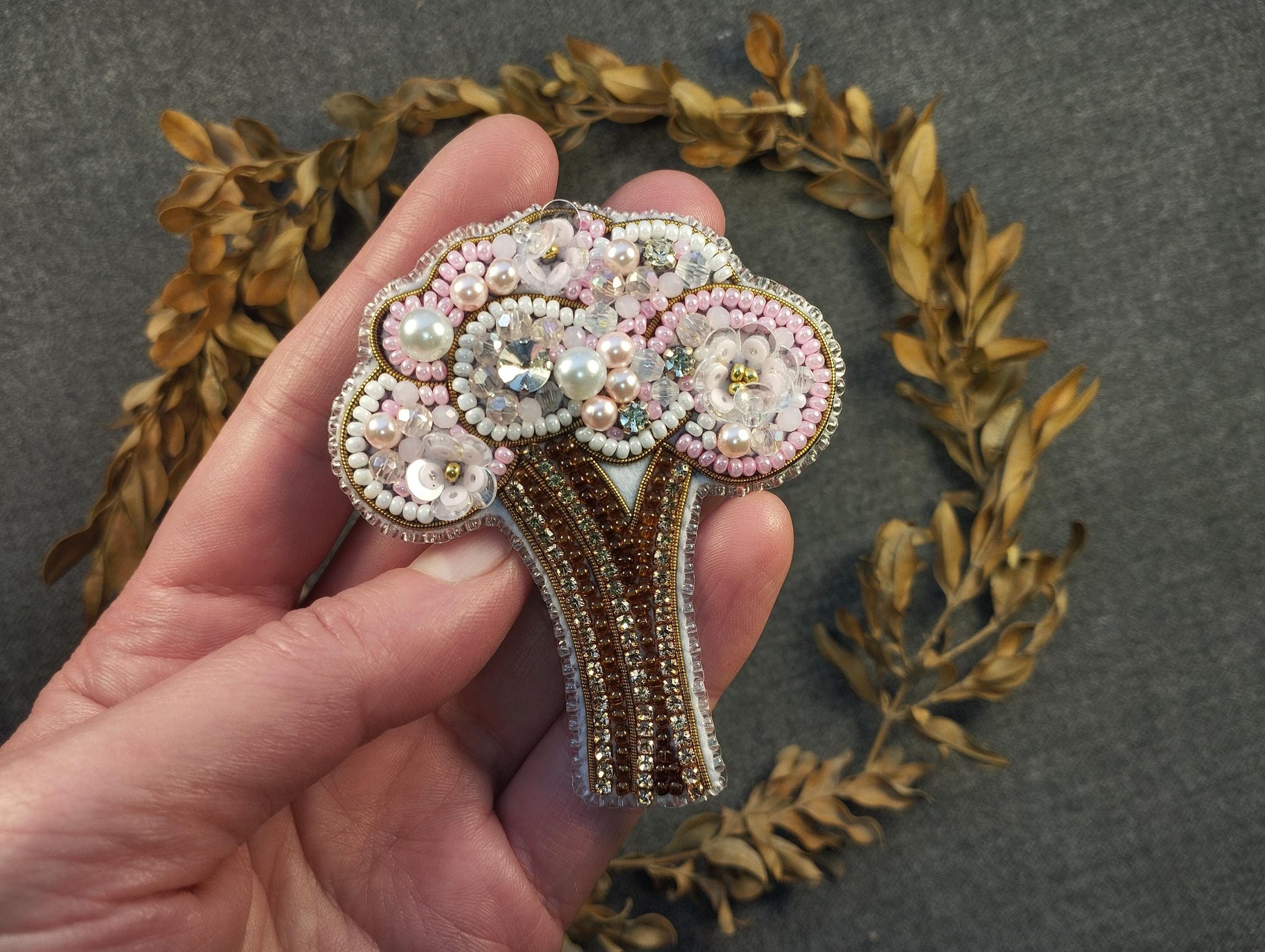 a person is holding a brooch in their hand