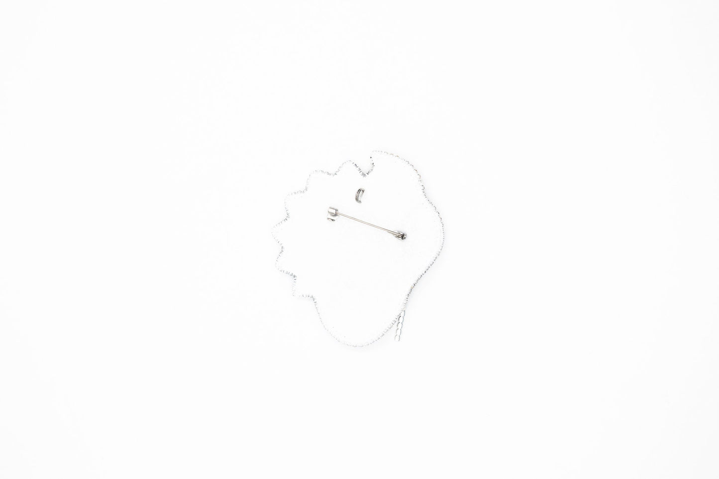 a hand is holding a decorative brooch