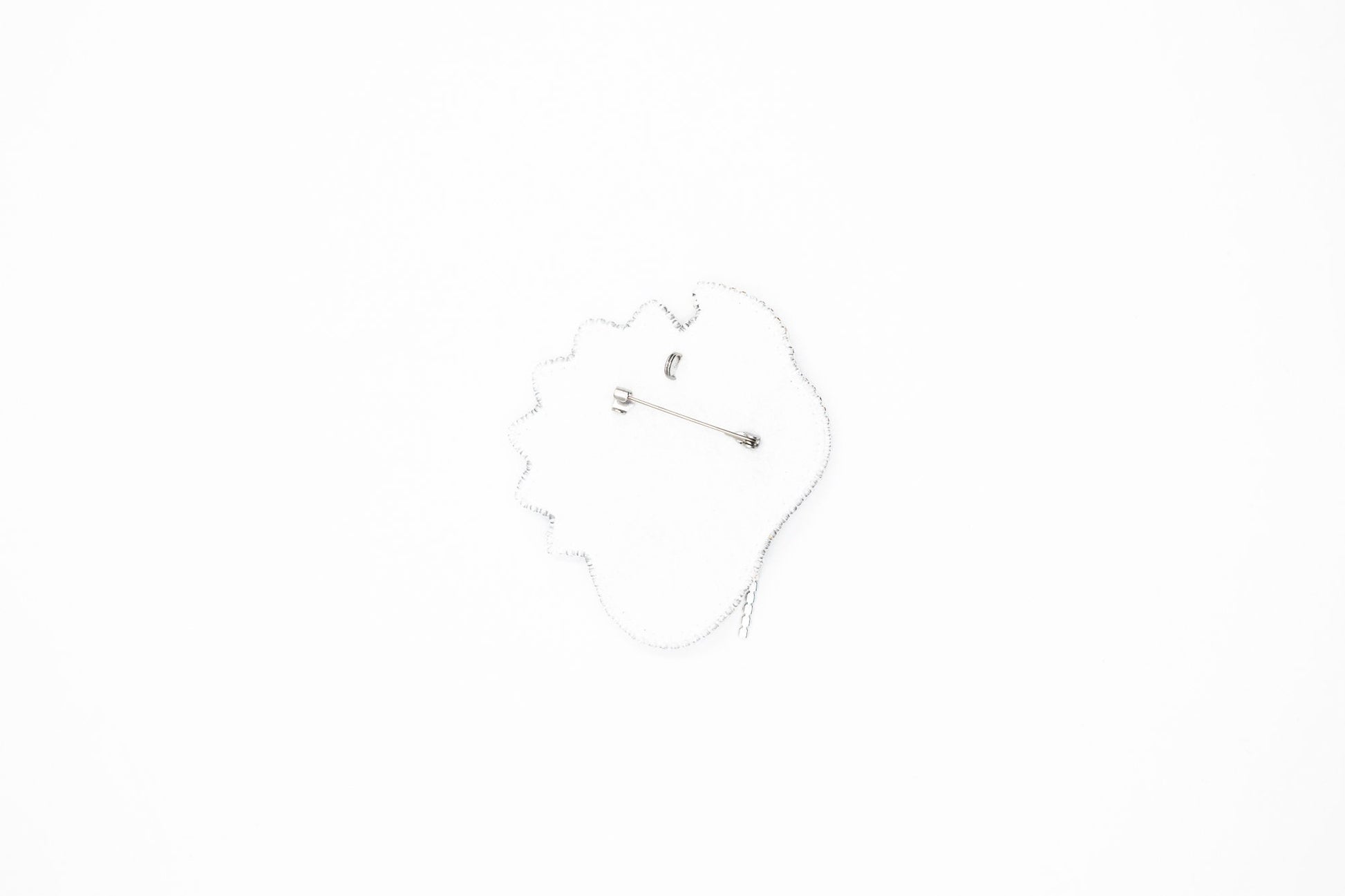 a hand is holding a decorative brooch