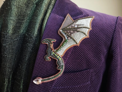A purple jacket with a decorative dragon pin or brooch on the lapel.
