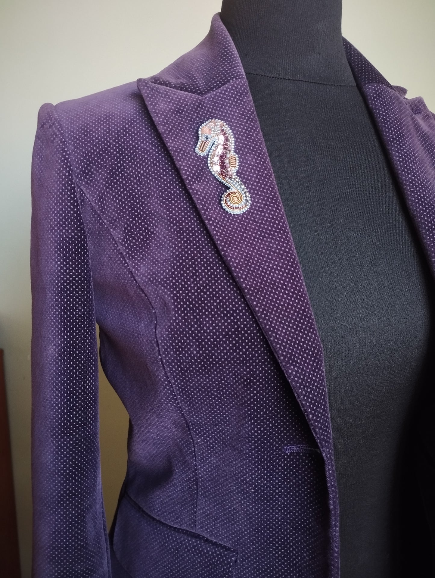 A purple suit jacket with a decorative pin on the left side.