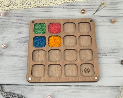 a wooden tray with beads and beads in it