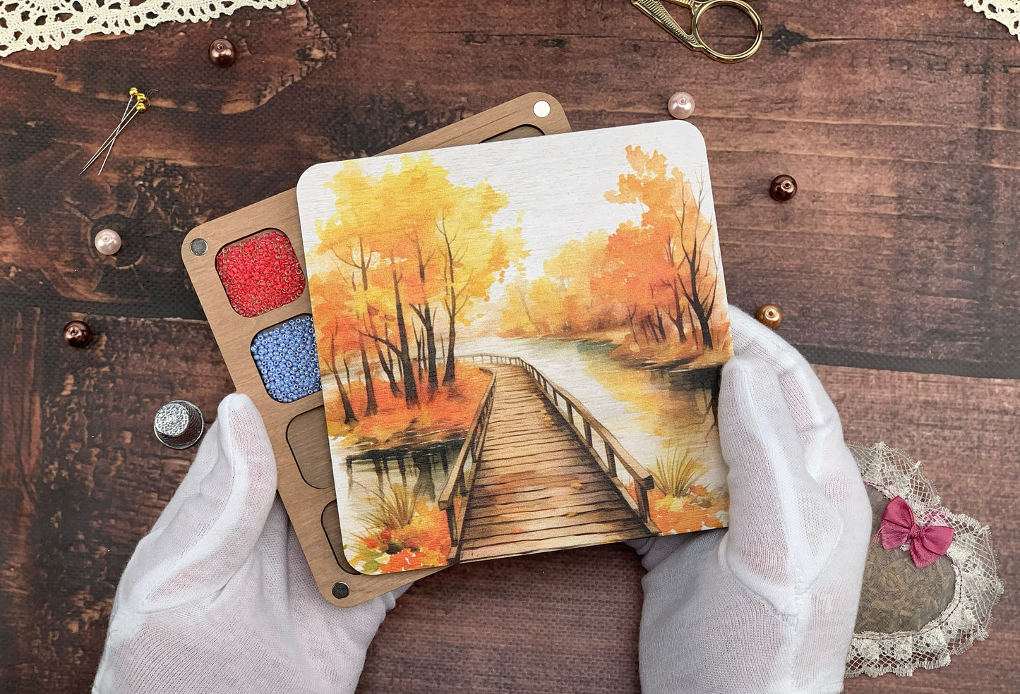 a person holding two cards with a painting on them