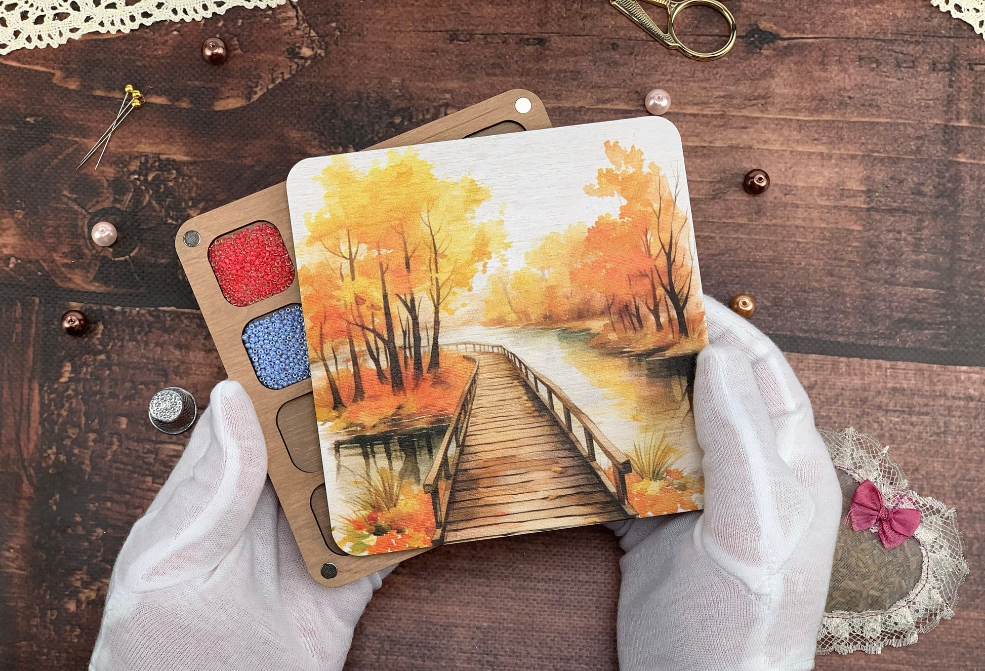 a person holding two cards with a painting on them