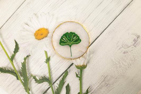 a flower and a leaf on a white wooden surface