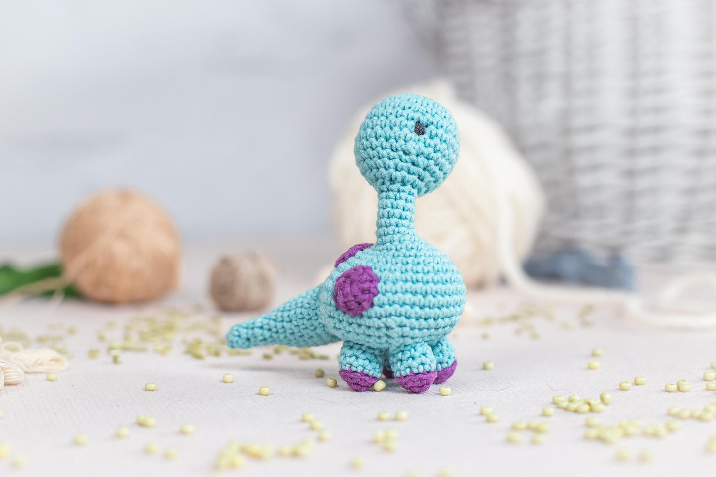 a crocheted toy of a dinosaur on a table