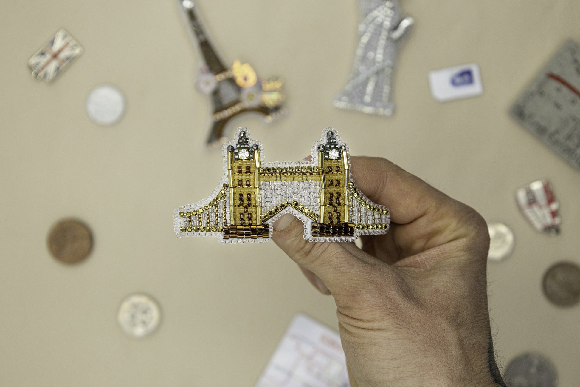 a person holding up a miniature model of a building