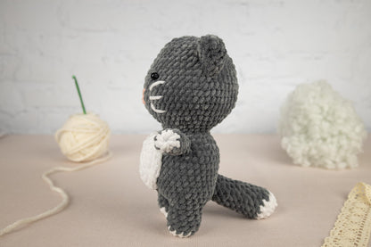 a crocheted stuffed animal sitting next to a ball of yarn