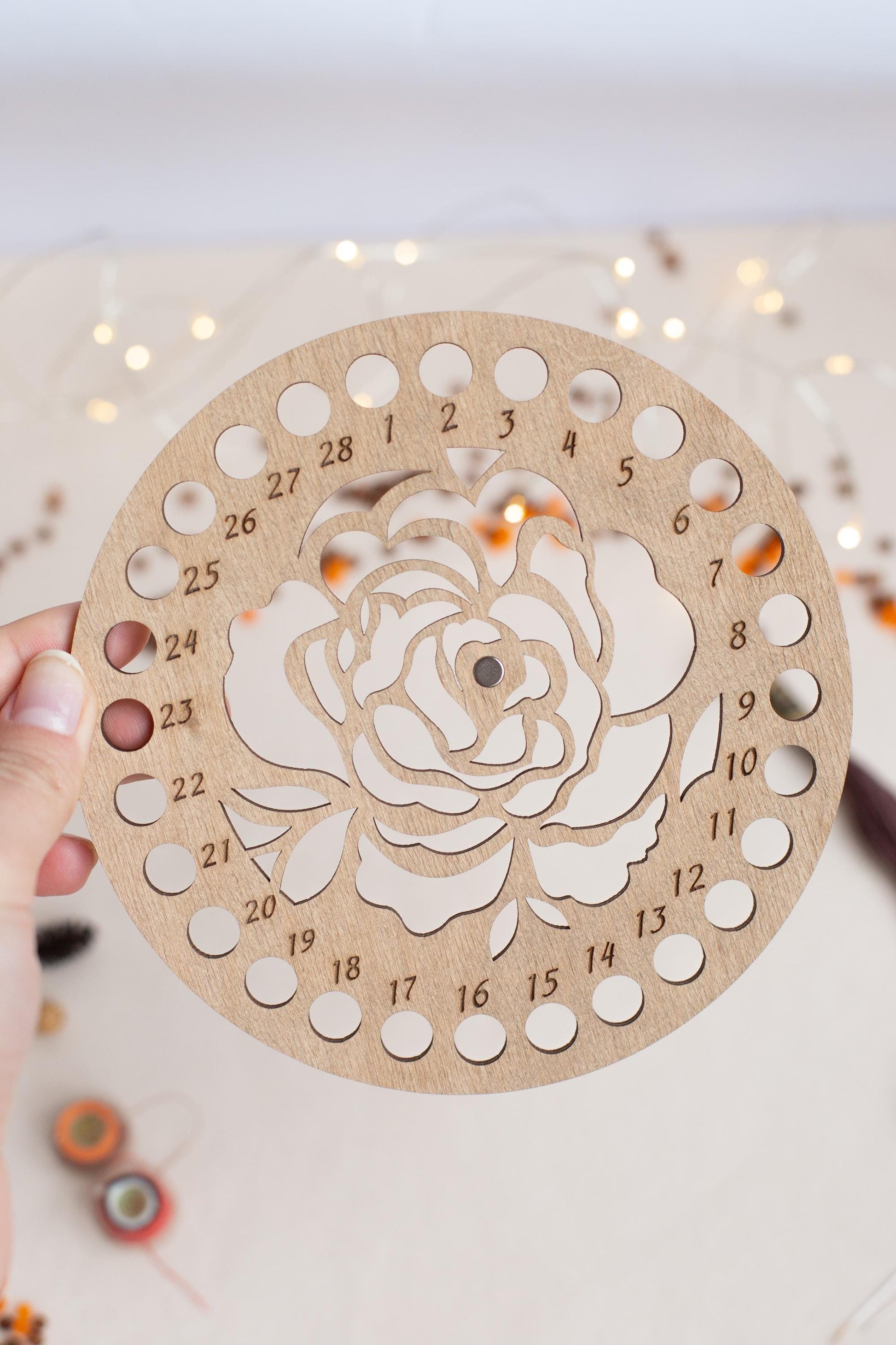 a person holding a wooden clock with a rose cut out of it