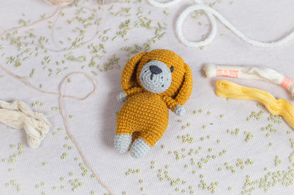 a crocheted teddy bear laying on a table