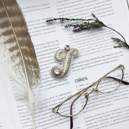 a close-up of a book with a feather and a pair of glasses resting on top of it.