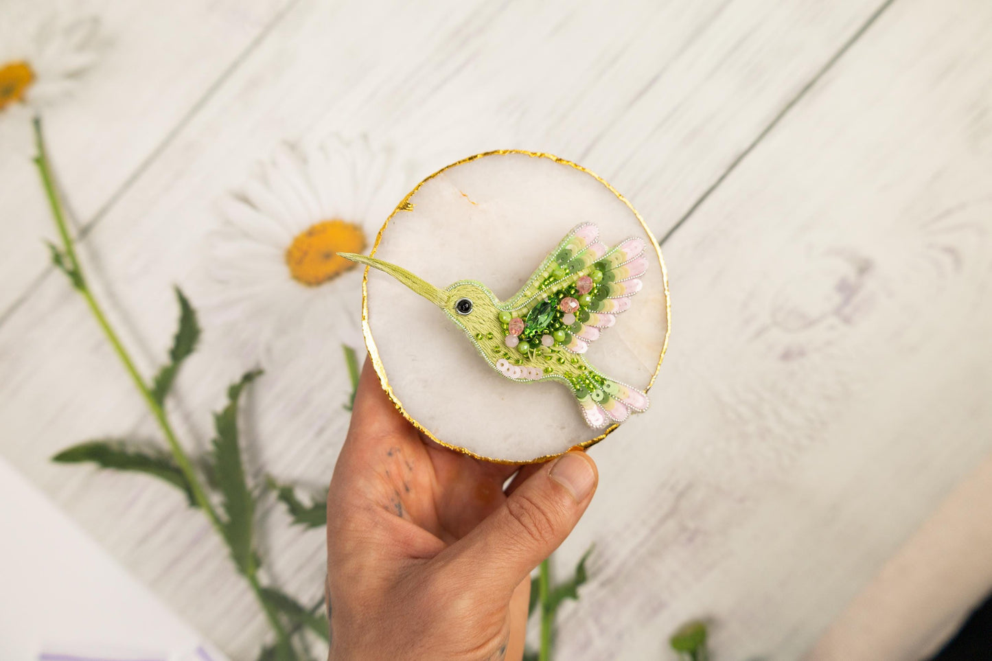 a person holding a small glass with a bird on it