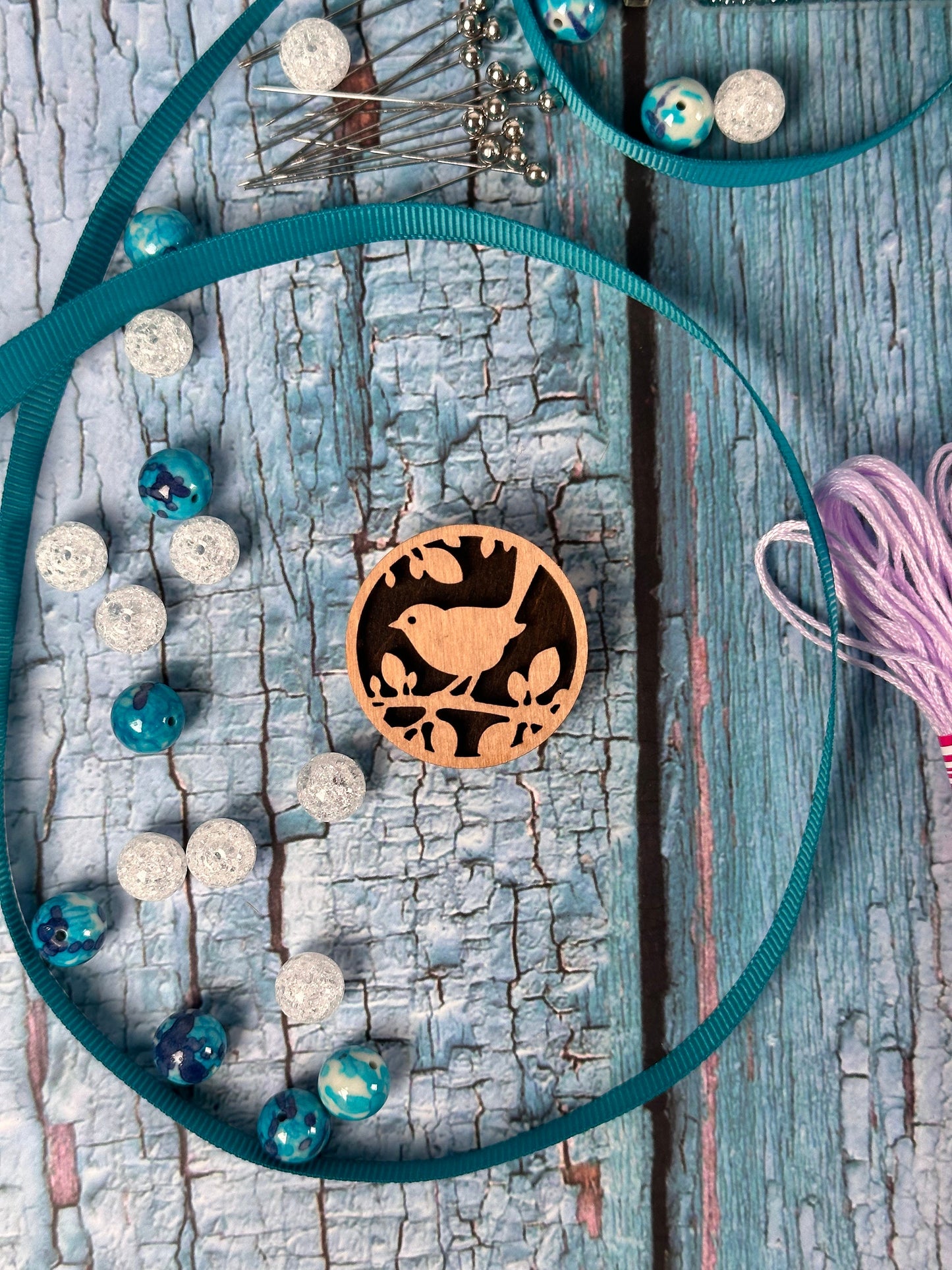 a necklace with beads and a tassel on a wooden surface