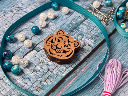 a wooden tiger keychain with a tassel on it