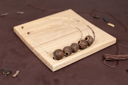 a wooden board with three beads on it