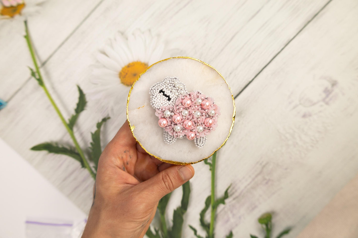 a person holding a cupcake decorated with flowers
