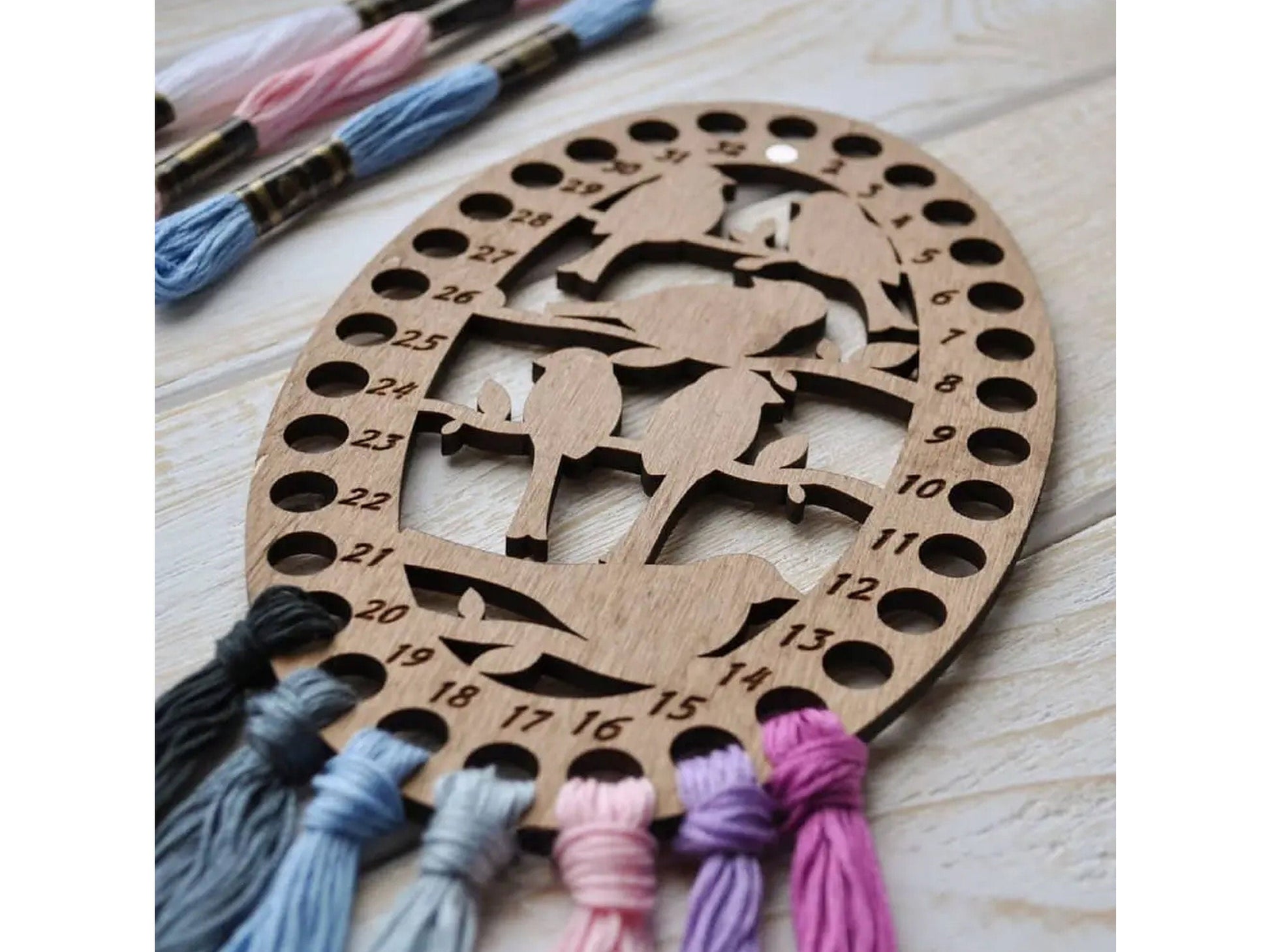 a wooden ornament with tassels and thread