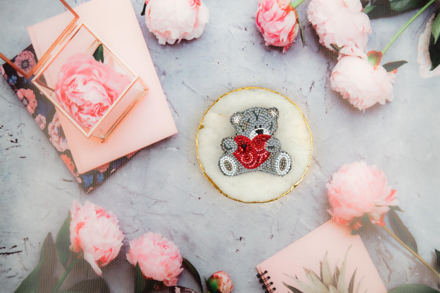 a teddy bear with a heart on it surrounded by pink flowers