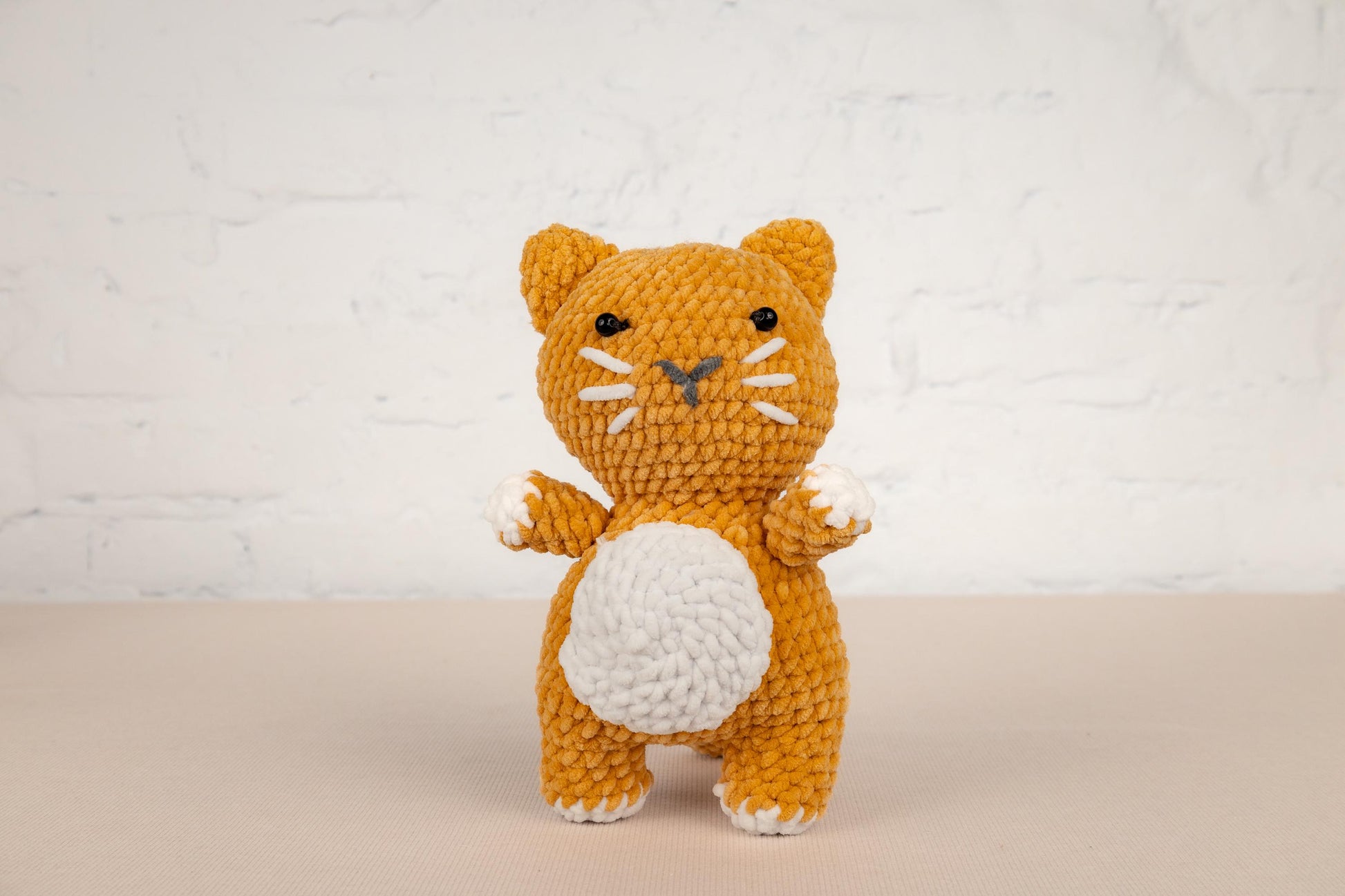 a small crocheted orange and white cat