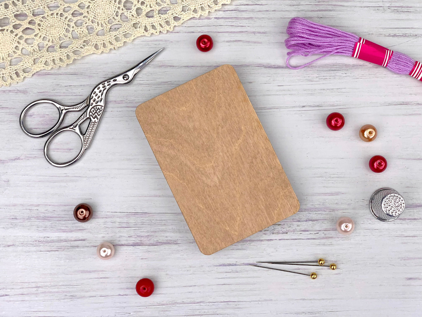 a wooden cutting board surrounded by sewing supplies