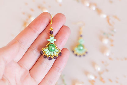 a woman's hand holding a pair of earrings