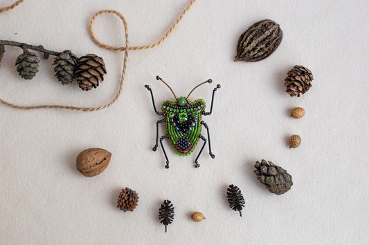 a green bug surrounded by pine cones and acorns