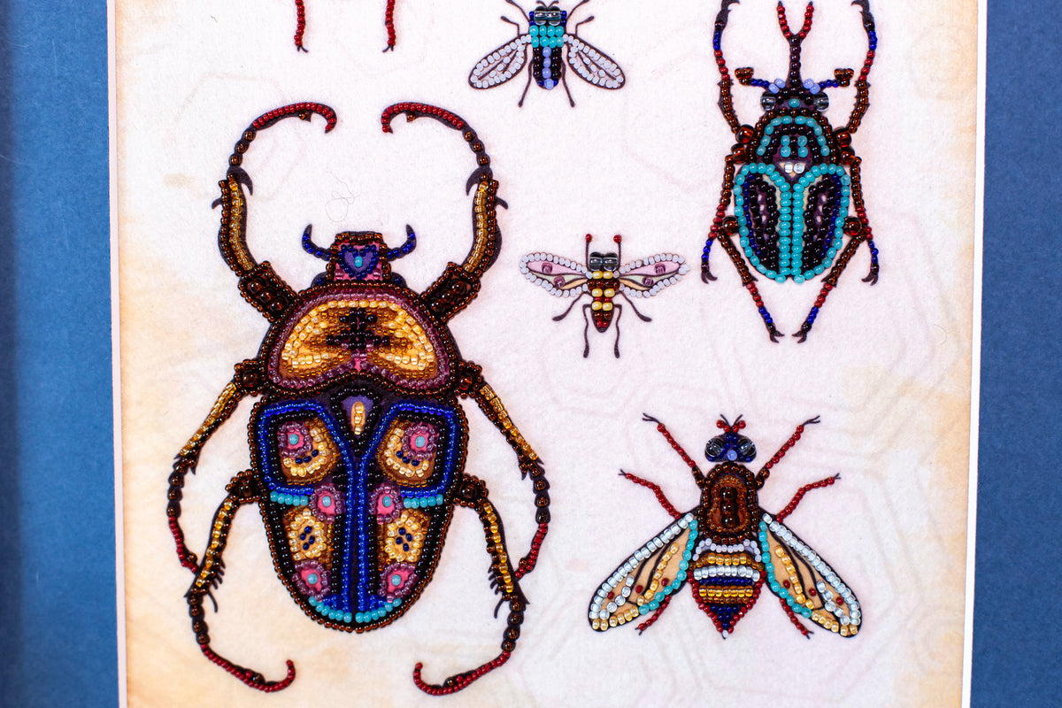 a detailed and colorful illustration of various insects, including a large dragonfly, a bee, and several other insects, all intricately crafted with beads and other embellishments.
