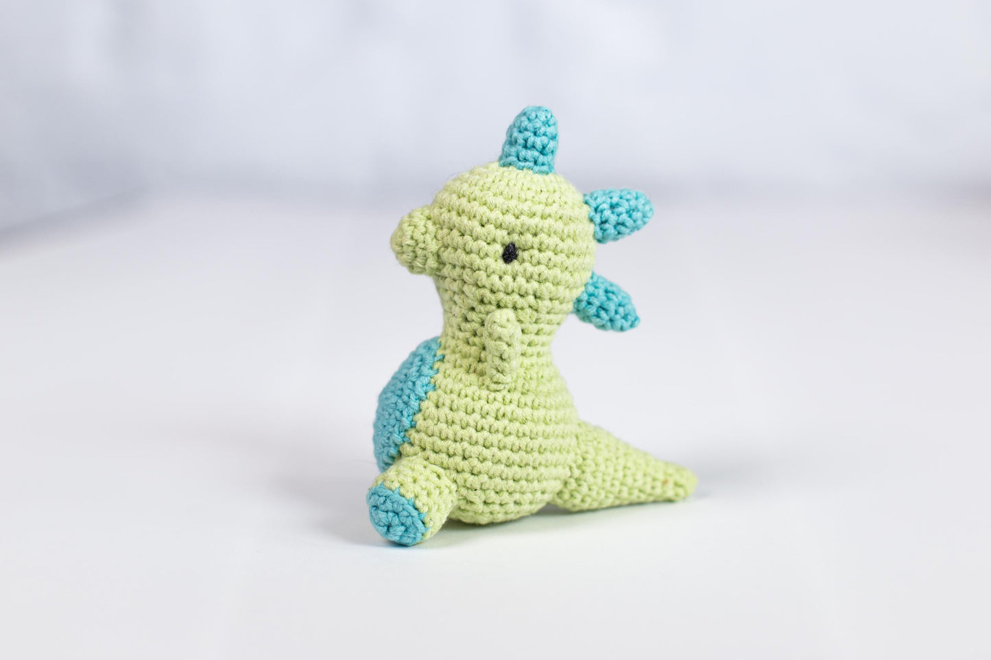 a crocheted stuffed animal sitting on a white surface