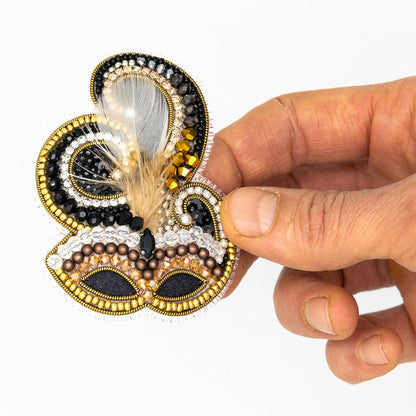 a hand holding a piece of beaded art