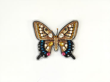 a butterfly made out of beads on a white surface