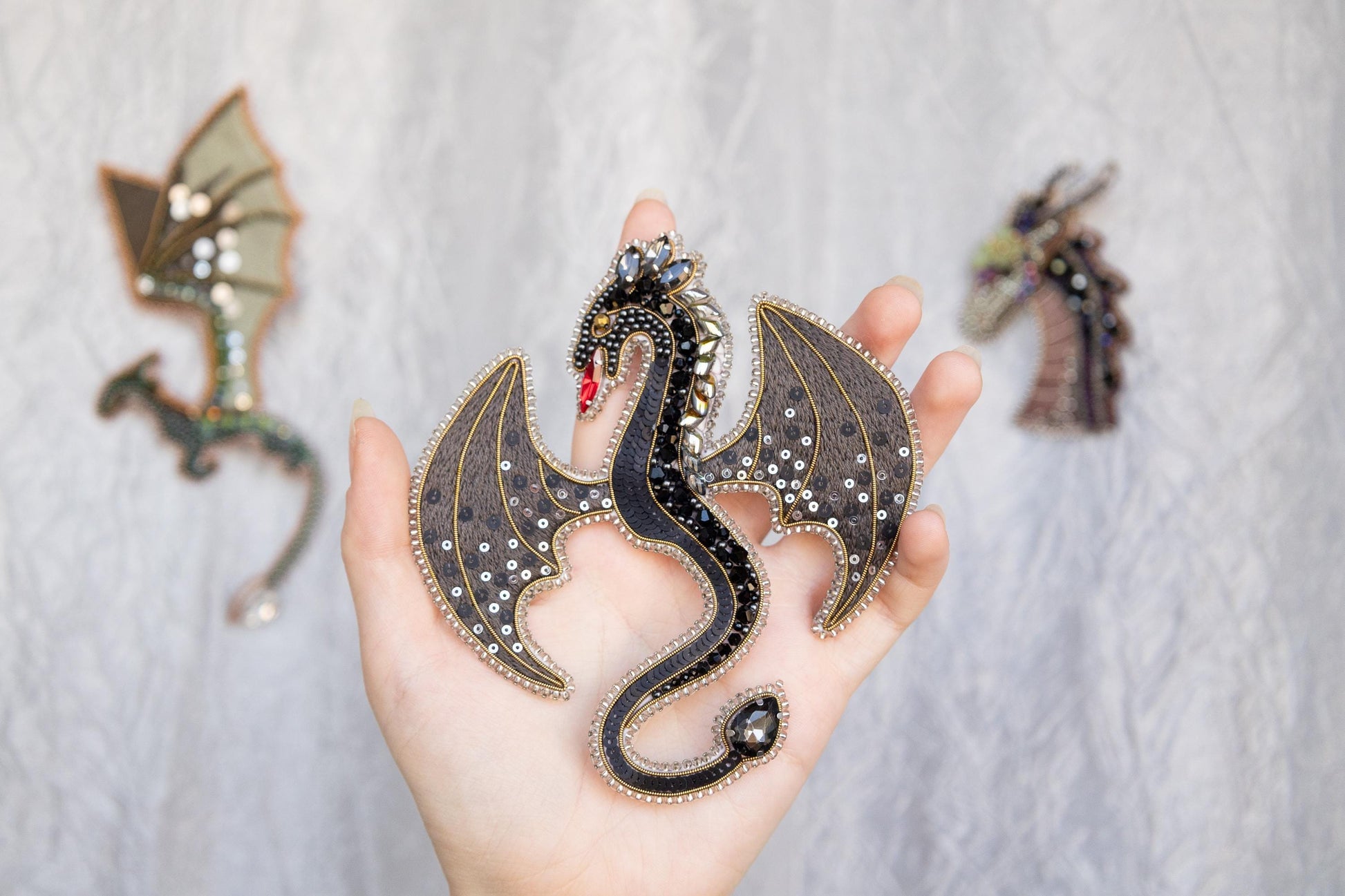 a hand holding a dragon figurine next to other dragon figurines