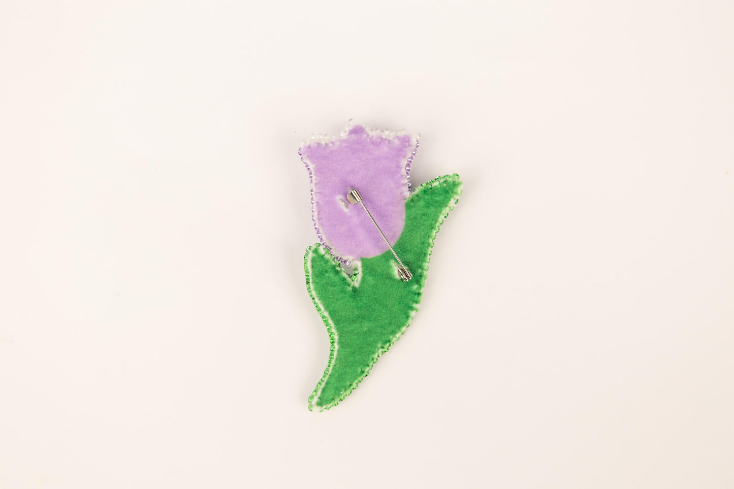 a purple flower with a green stem on a white background