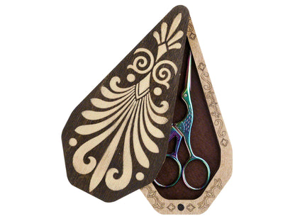 a pair of scissors sitting inside of a wooden case