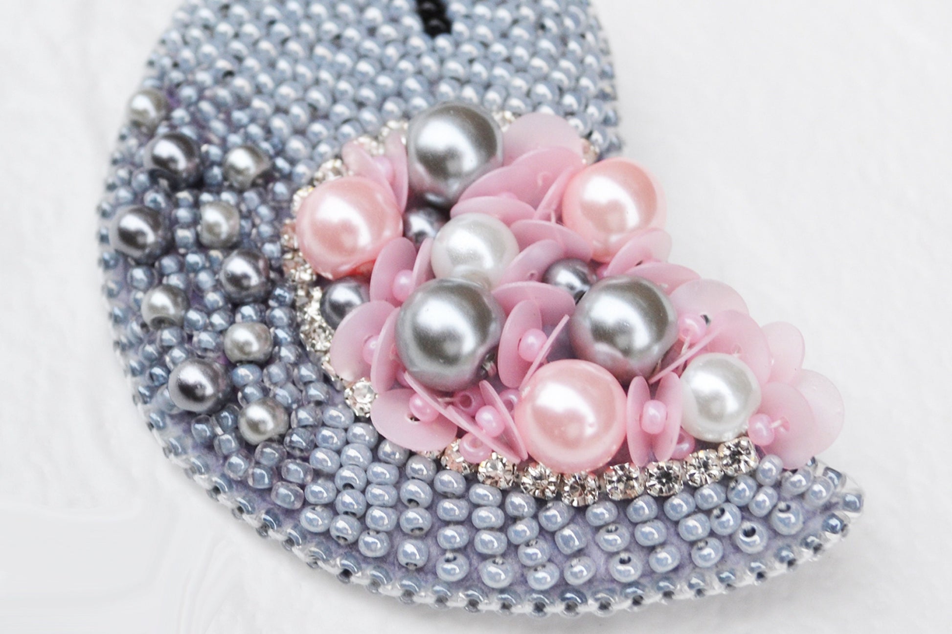 a purse with pearls and flowers on it