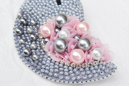 a purse with pearls and flowers on it