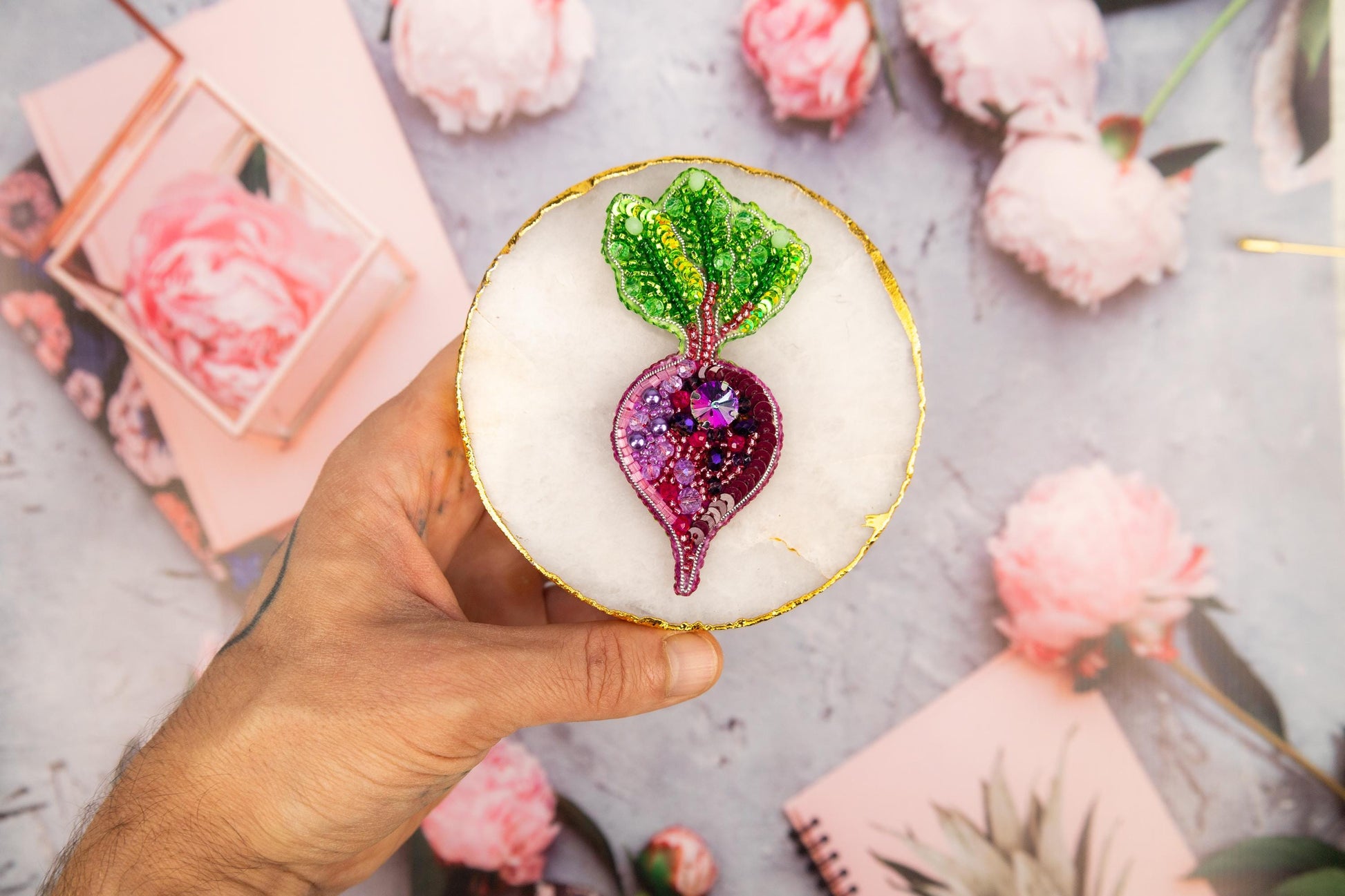 a person holding a small cake with a plant on top of it