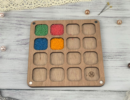 a wooden tray with beads and beads in it