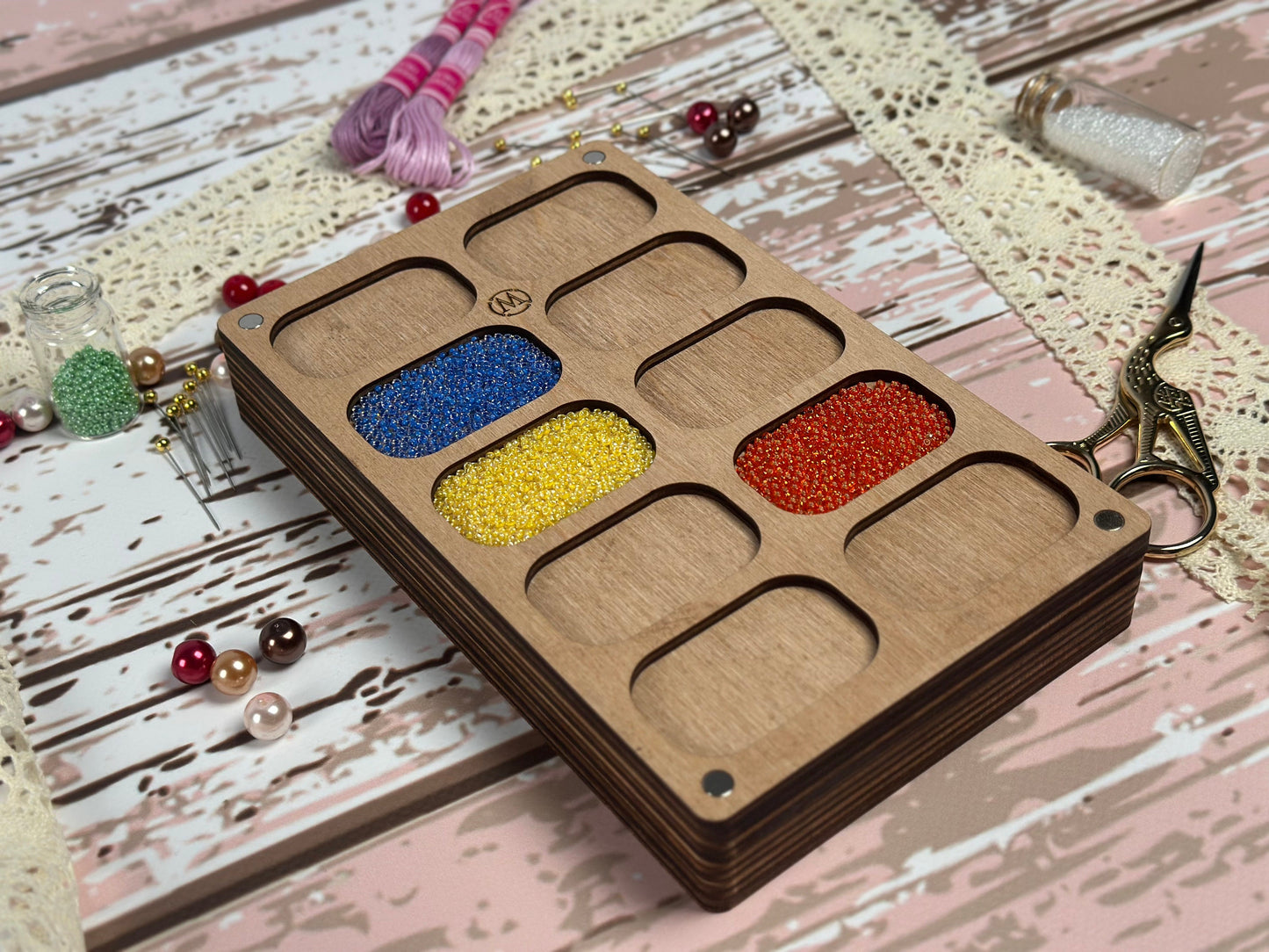 a wooden box with four compartments filled with beads