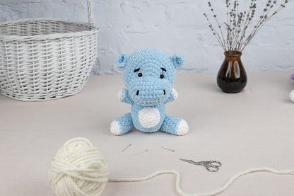 a crocheted stuffed animal sitting on a table next to a ball of yarn