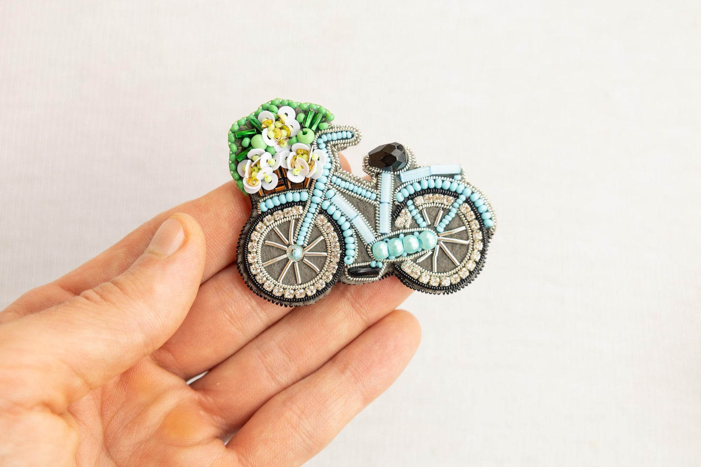 a person is holding a brooch with a bike on it