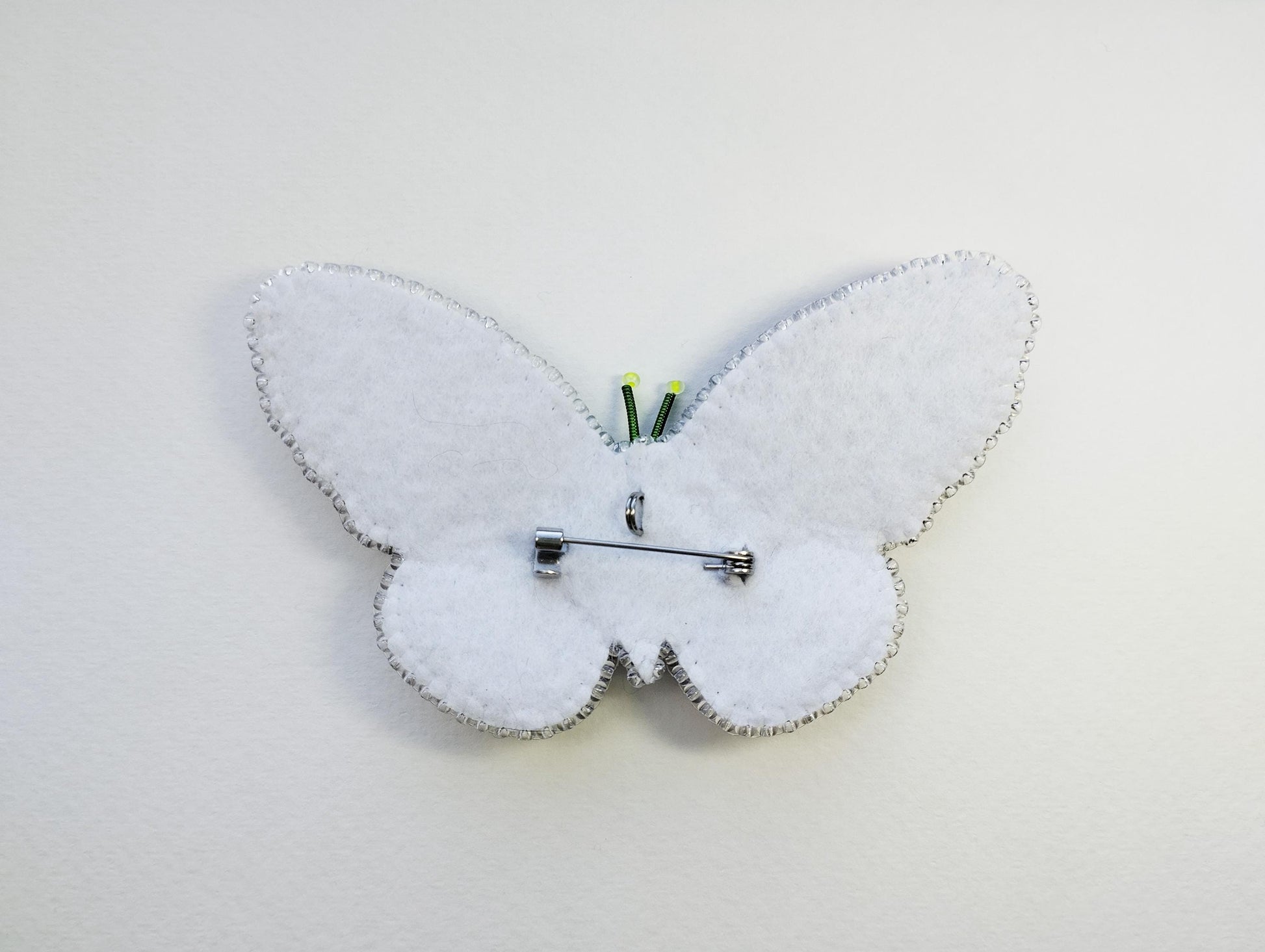 a white clock with a butterfly design on it