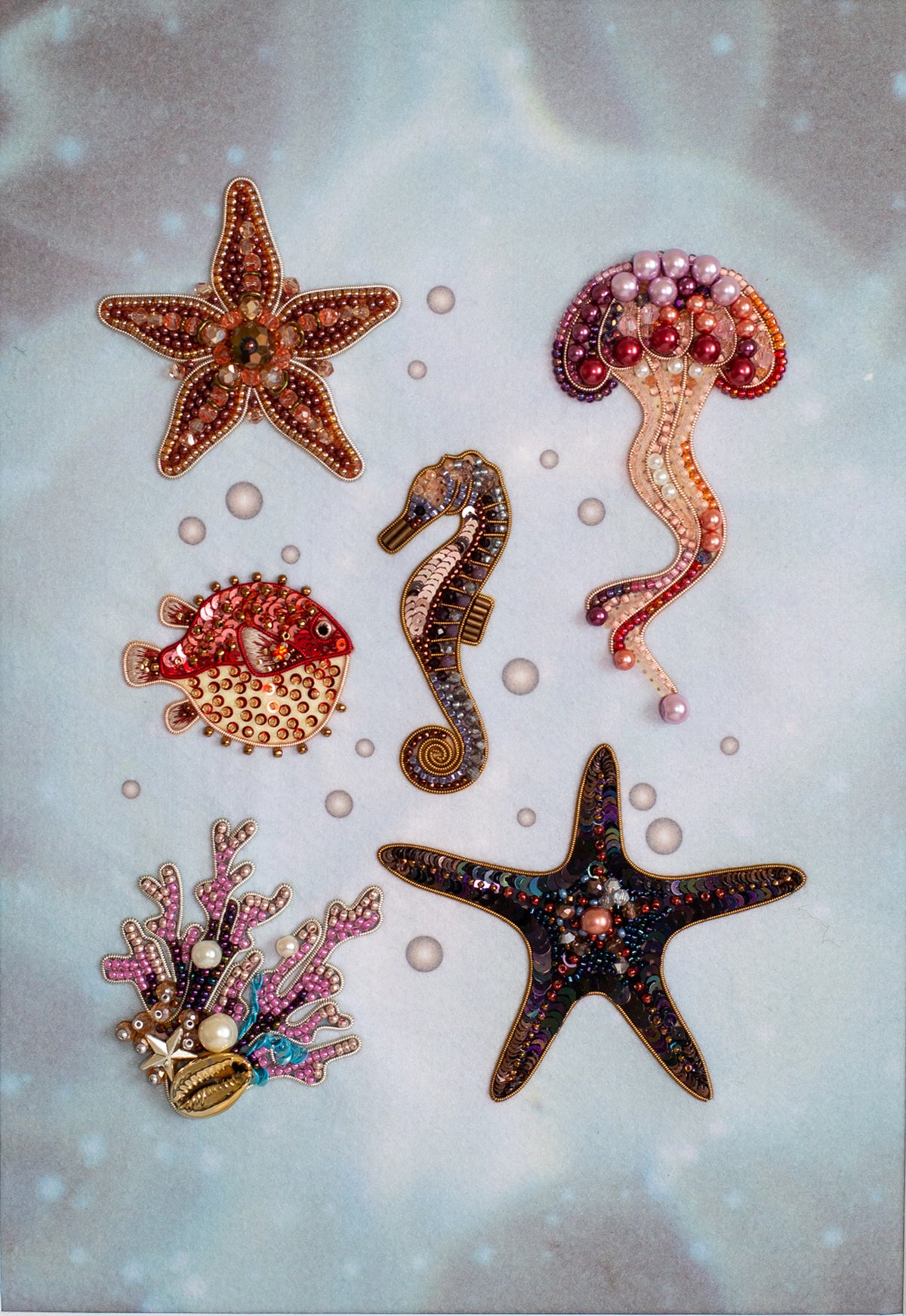 a collection of six decorative sea-themed items, including a starfish, a jellyfish, a seahorse, a pufferfish, a coral, and a starfish, all adorned with intricate beading and embellishments.