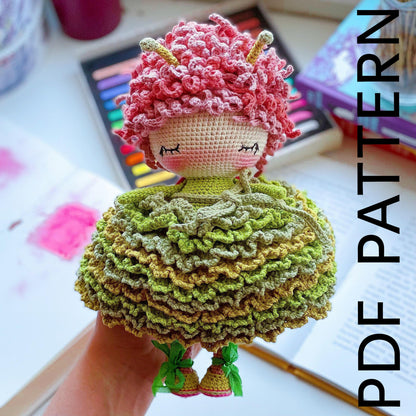 a crocheted doll is sitting on a table