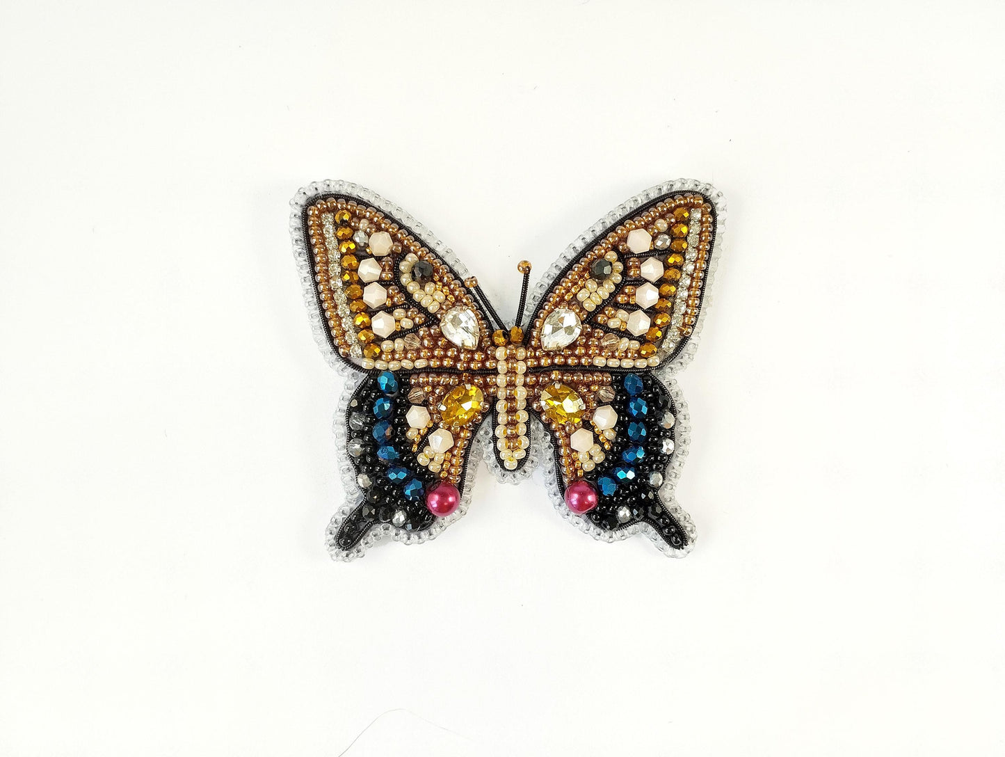 a butterfly made out of beads on a white surface