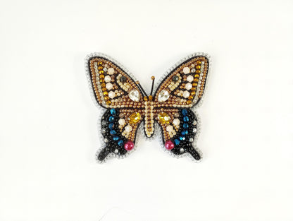 a butterfly made out of beads on a white surface