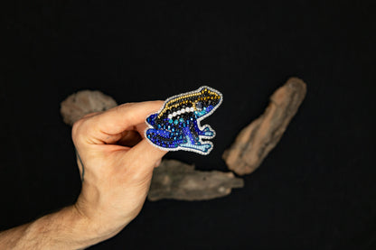 a hand holding a sticker of a frog