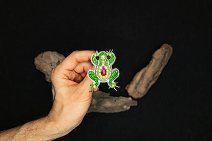 a person is holding a brooch in their hand