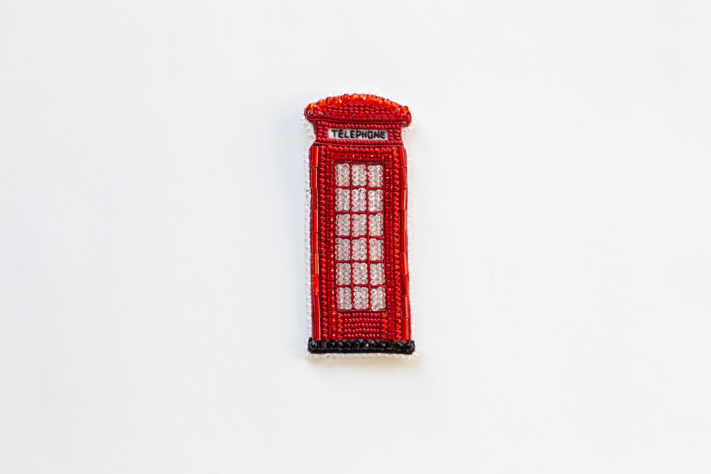 a red beaded phone booth on a white surface